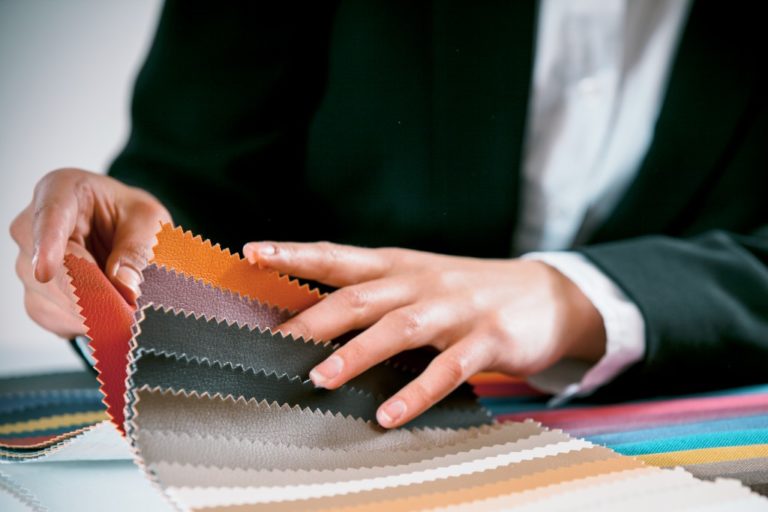 businessperson holding swatches of leathers