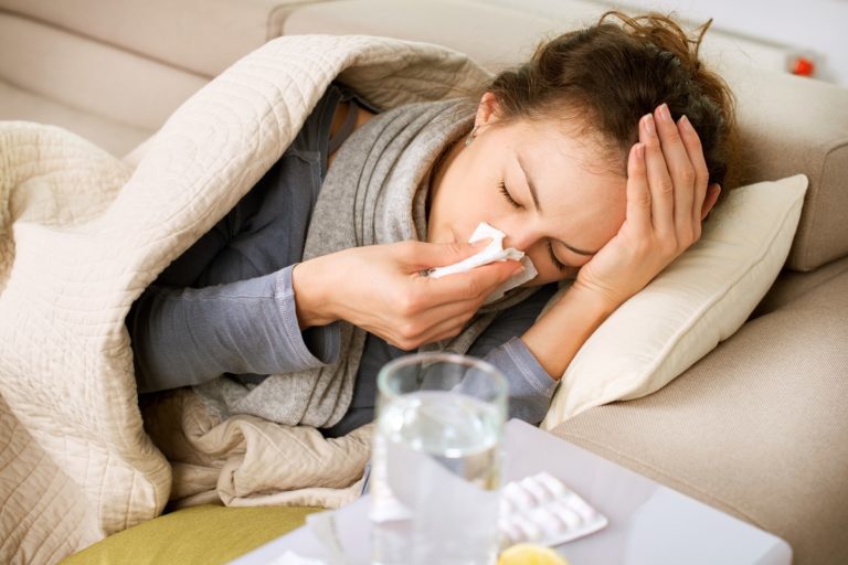 Girl with colds lying down on couch