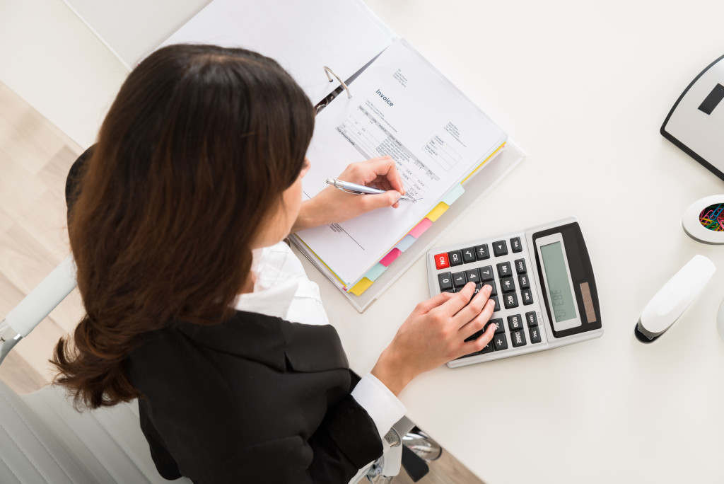 accounting staff doing her work while using calculator