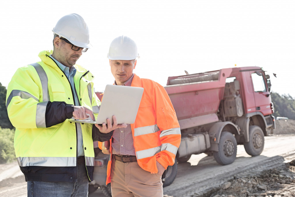 2 person using a laptop in construction site
