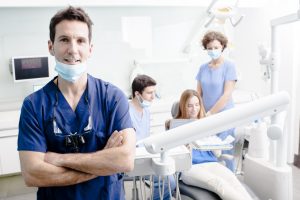 A dentist and his team working on a client