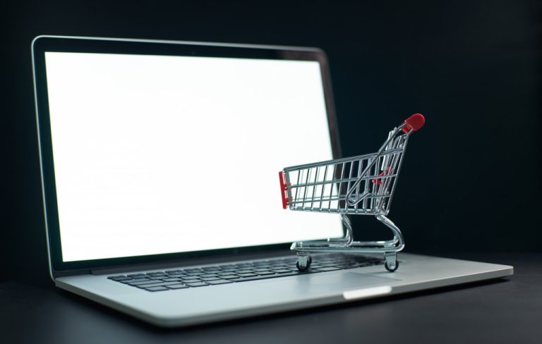 a laptop with a miniature shopping cart