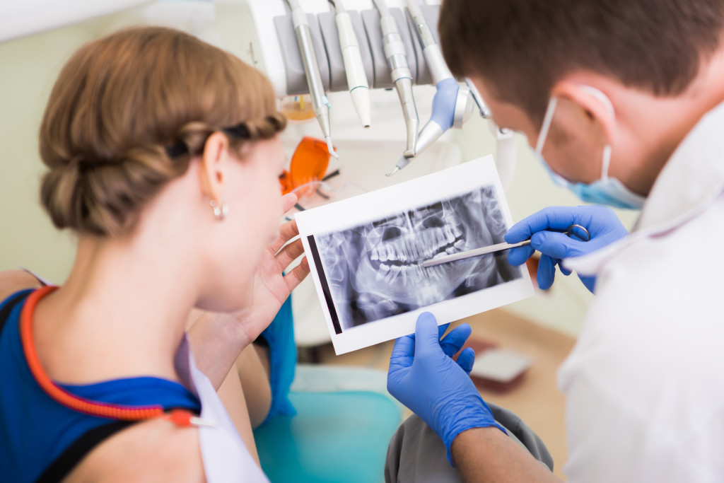doctor showing woman her teeth xray