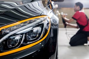 auto detailing on a black car done by man