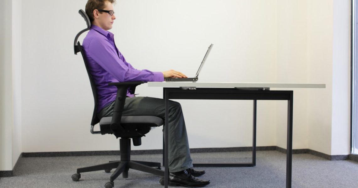 man doing work on his computer while sitting on a chair
