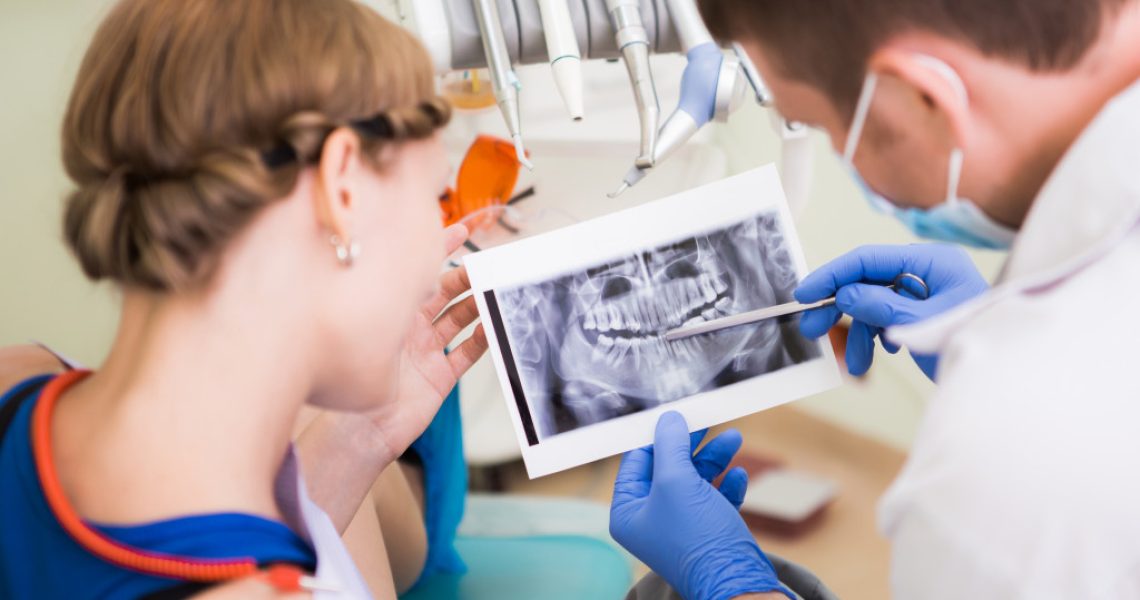 doctor showing woman her teeth xray